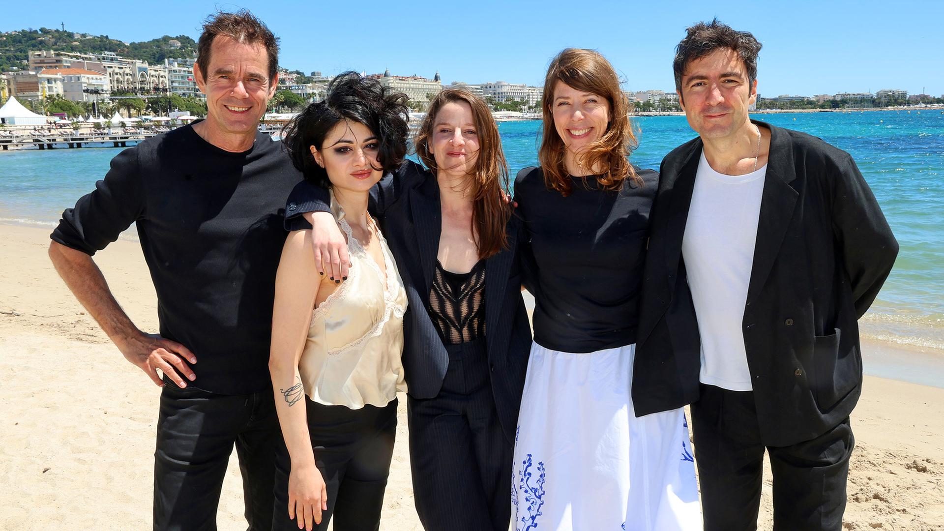 Die Filmschaffenden v.l.n.r. Tom Tykwer, Kurdwin Ayub, Helene Hegemann, Nora Fingscheidt, İlker Çatak am Strand von Cannes. | X Filme, Zentropa Germany