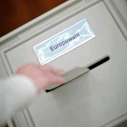 Eine Hand wirft einen Stimmzettel in den Schlitz einer Wahlurne mit der Aufschrift Europawahl