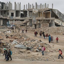 Kinder in Syrien gehen auf ihrem Schulweg an von Luftangriffen zerstörten Gebäuden vorbei. (Archivbild vom 21.11.2021)