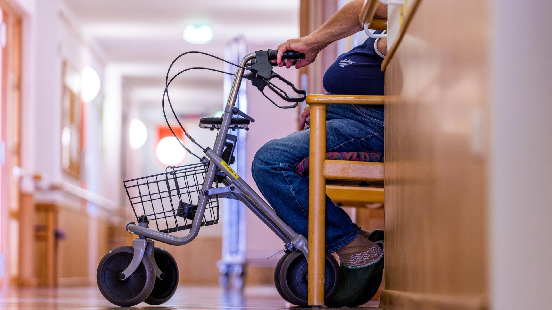 Ein Bewohner sitzt mit seinem Rollator im Flur eines Pflegeheims | dpa