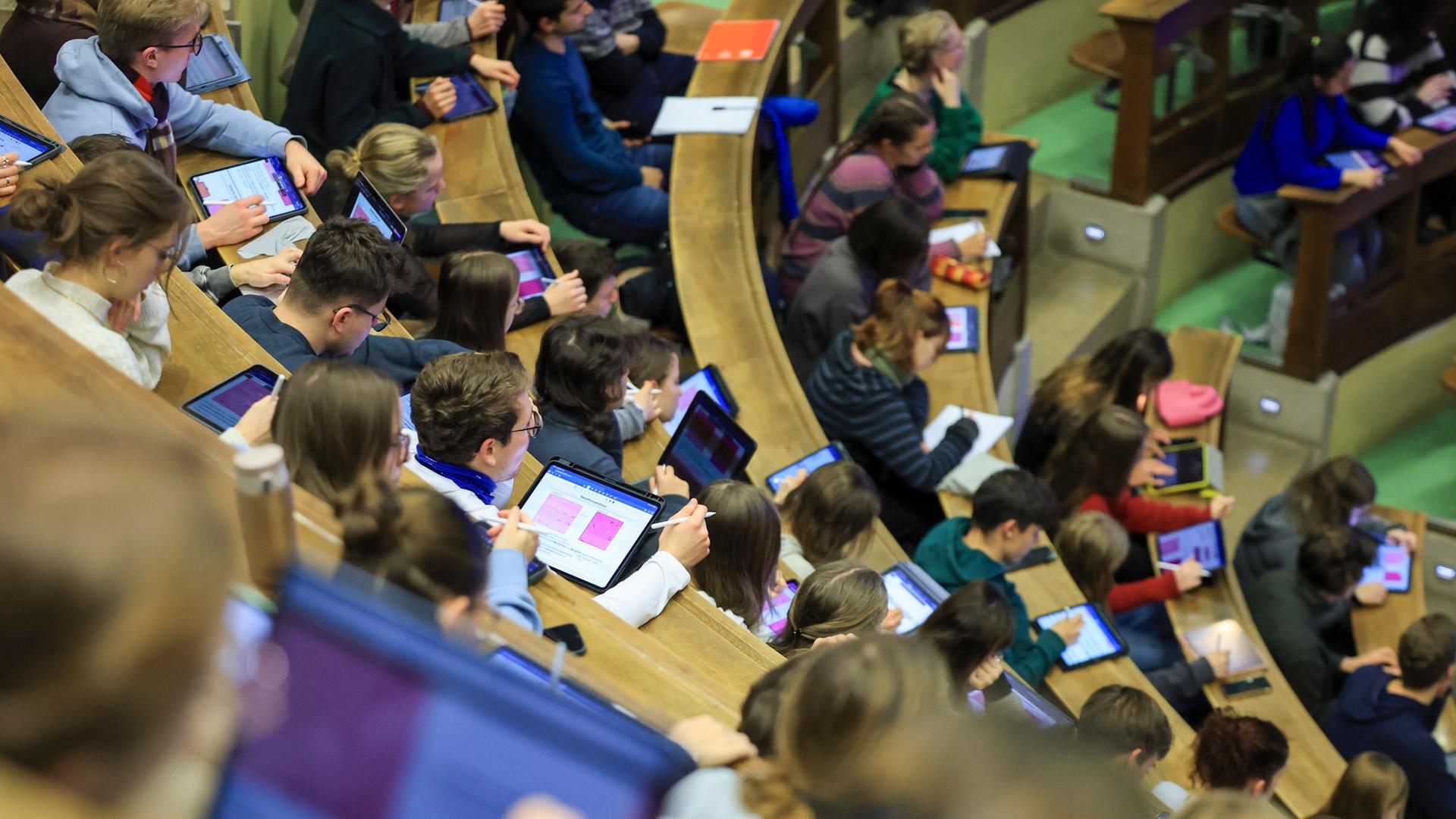 Studentinnen und Studenten sitzen in einer Vorlesung der Universität Leipzig. | Jan Woitas/dpa