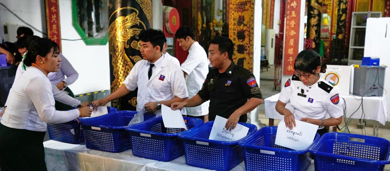 Beamte bereiten sich darauf vor, Stimmzettel in einem Wahllokal auszuzählen.