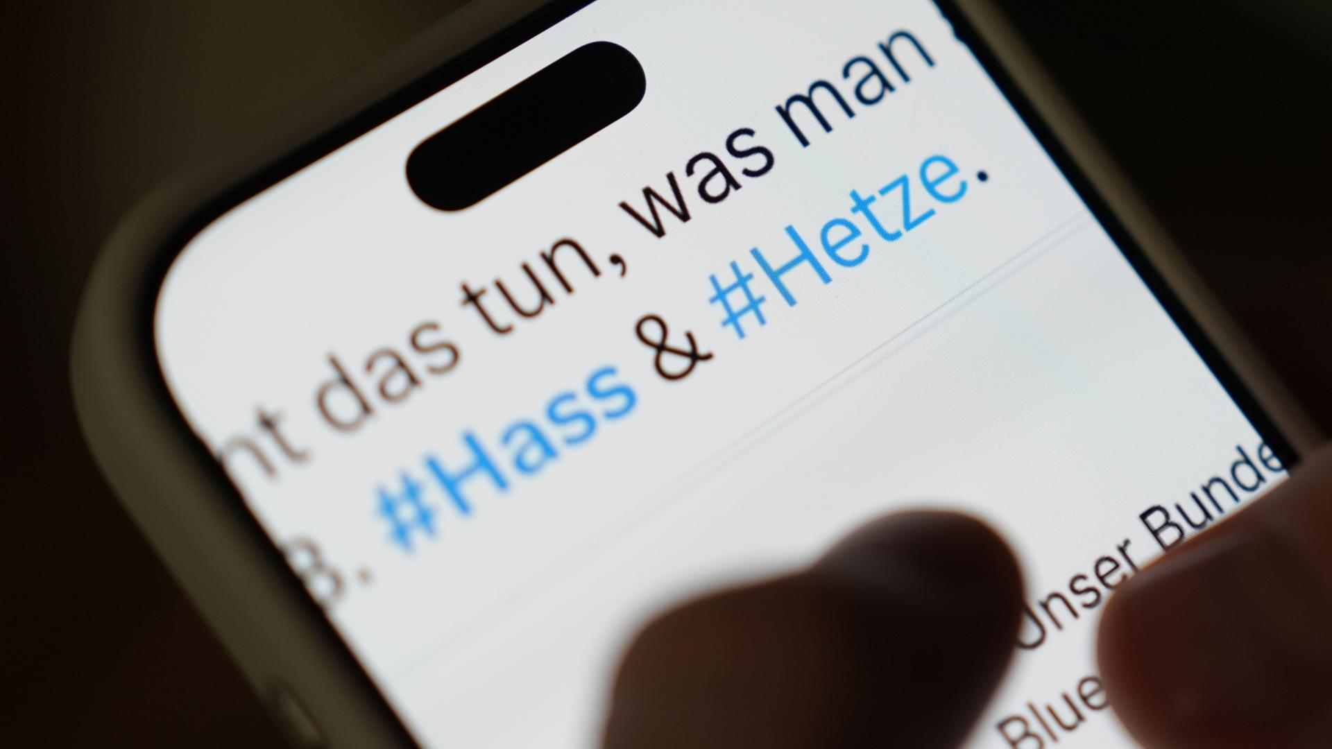 Auf dem Bildschirm eines Smartphones sind in einem Beitrag eines sozialen Netzwerks die Hashtags #Hass und #Hetze zu sehen.  | dpa