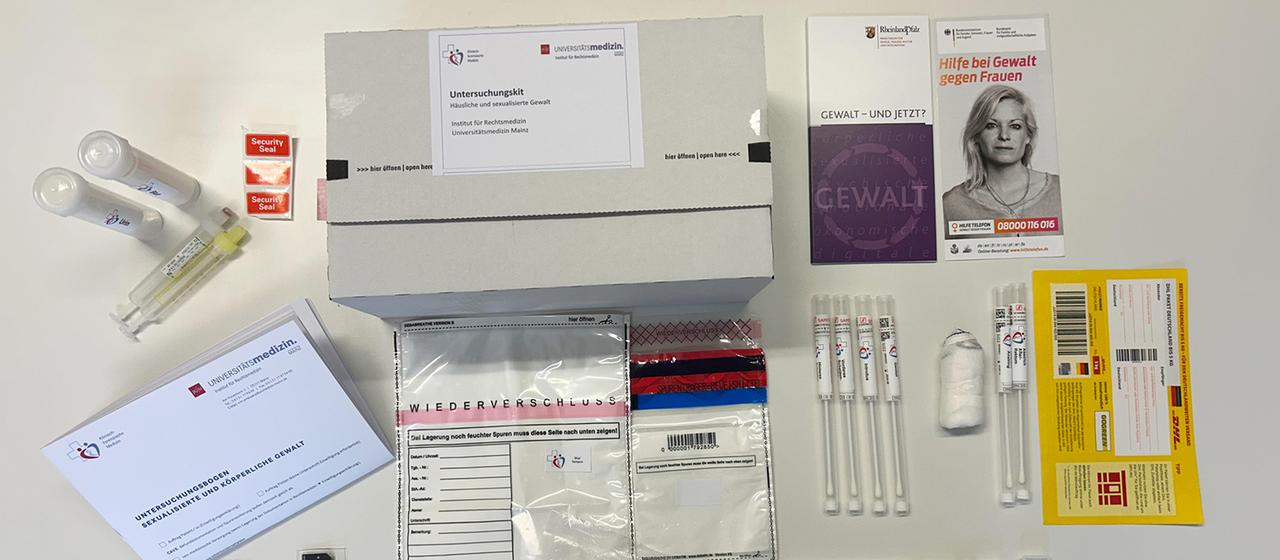 Der Inhalt aus einem Paket mit der Beschriftung "Untersuchungskit - häusliche und sexualisierte Gewalt" liegt ausgebreitet auf einem Tisch.