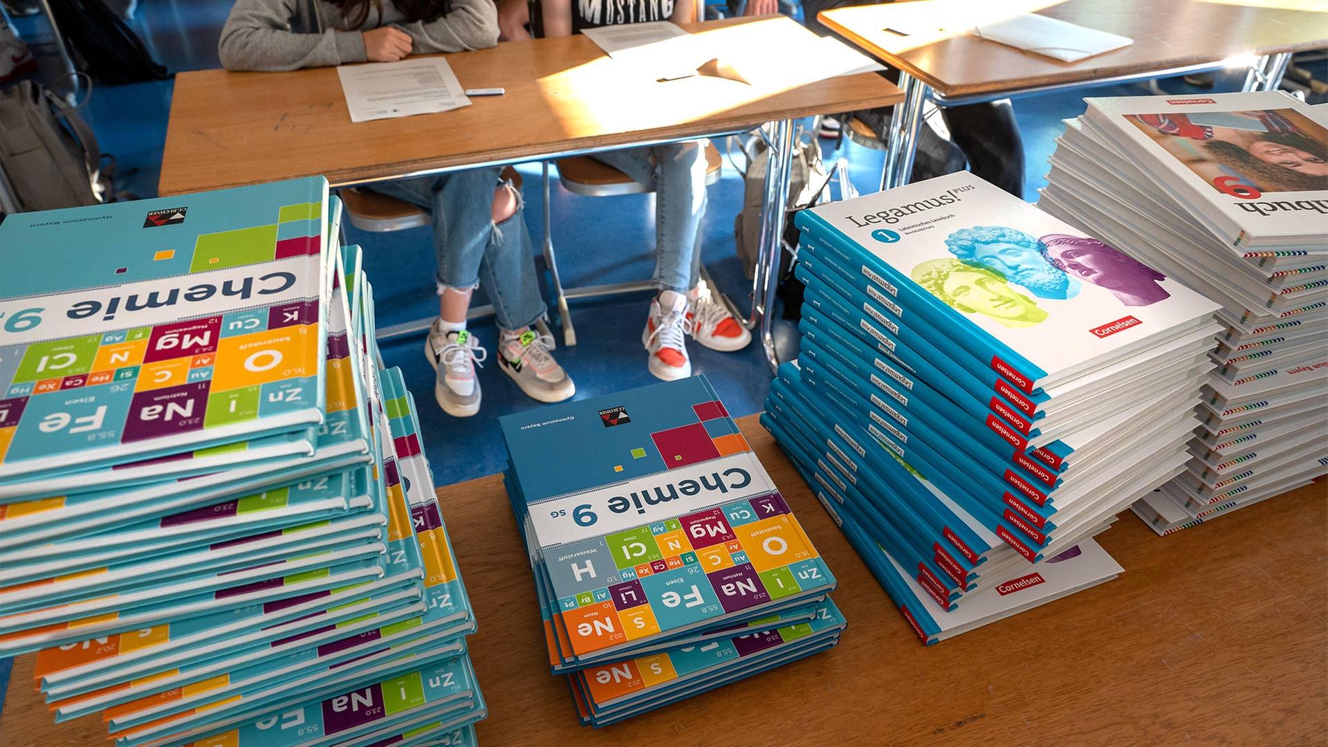 Schulbücher liegen auf einem Tisch in einem Klassenzimmer. | picture alliance/dpa