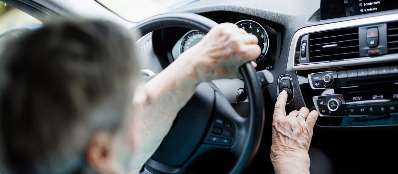 Eine Seniorin sitzt am Steuer eines Pkw