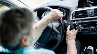 Eine Seniorin sitzt am Steuer eines Pkw