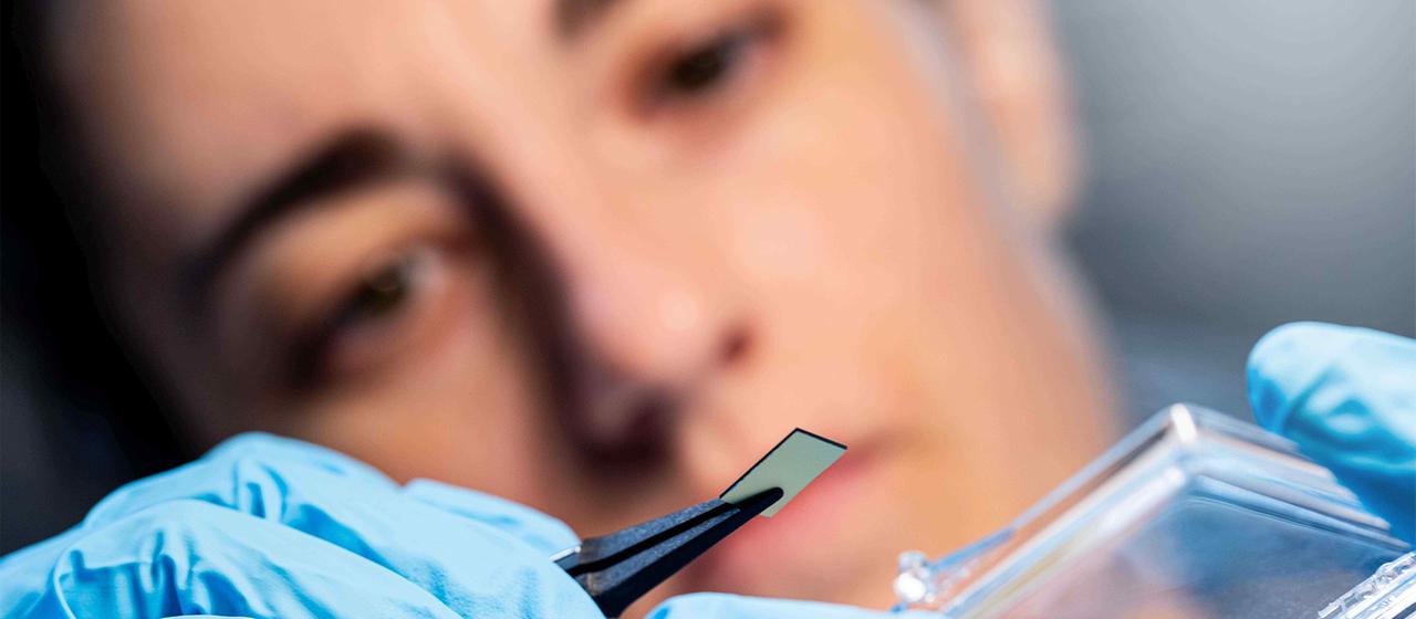 Ein Chip wird mit einer Zange gegriffen. | QANT Ein Chip wird mit einer Zange gegriffen.
