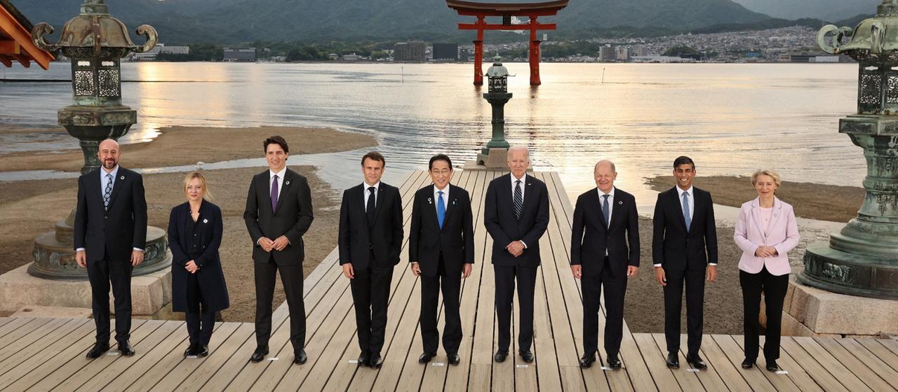 Gruppenbild der G7-Staats- und Regierungschefs am Itsukushima-Schrein auf der Insel Miyajima nahe Hiroshima, im Hintergrund die untergehende Sonne.