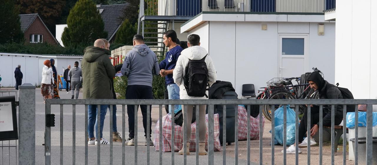 Flüchtlinge aus Syrien stehen nach ihrer Ankunft auf dem Gelände einer Flüchtlingsunterkunft. (Archivbild vom 17.10.2023) 