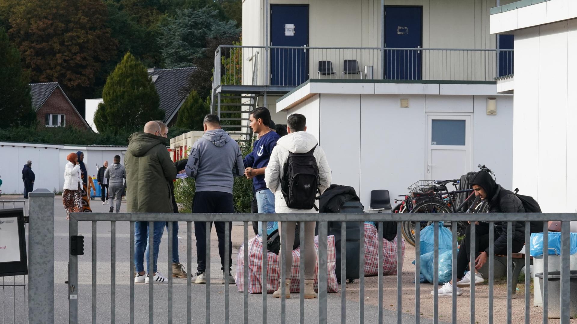 Flchtlinge aus Syrien stehen nach ihrer Ankunft auf dem Gelnde einer Flchtlingsunterkunft. (Archivbild vom 17.10.2023)  | dpa