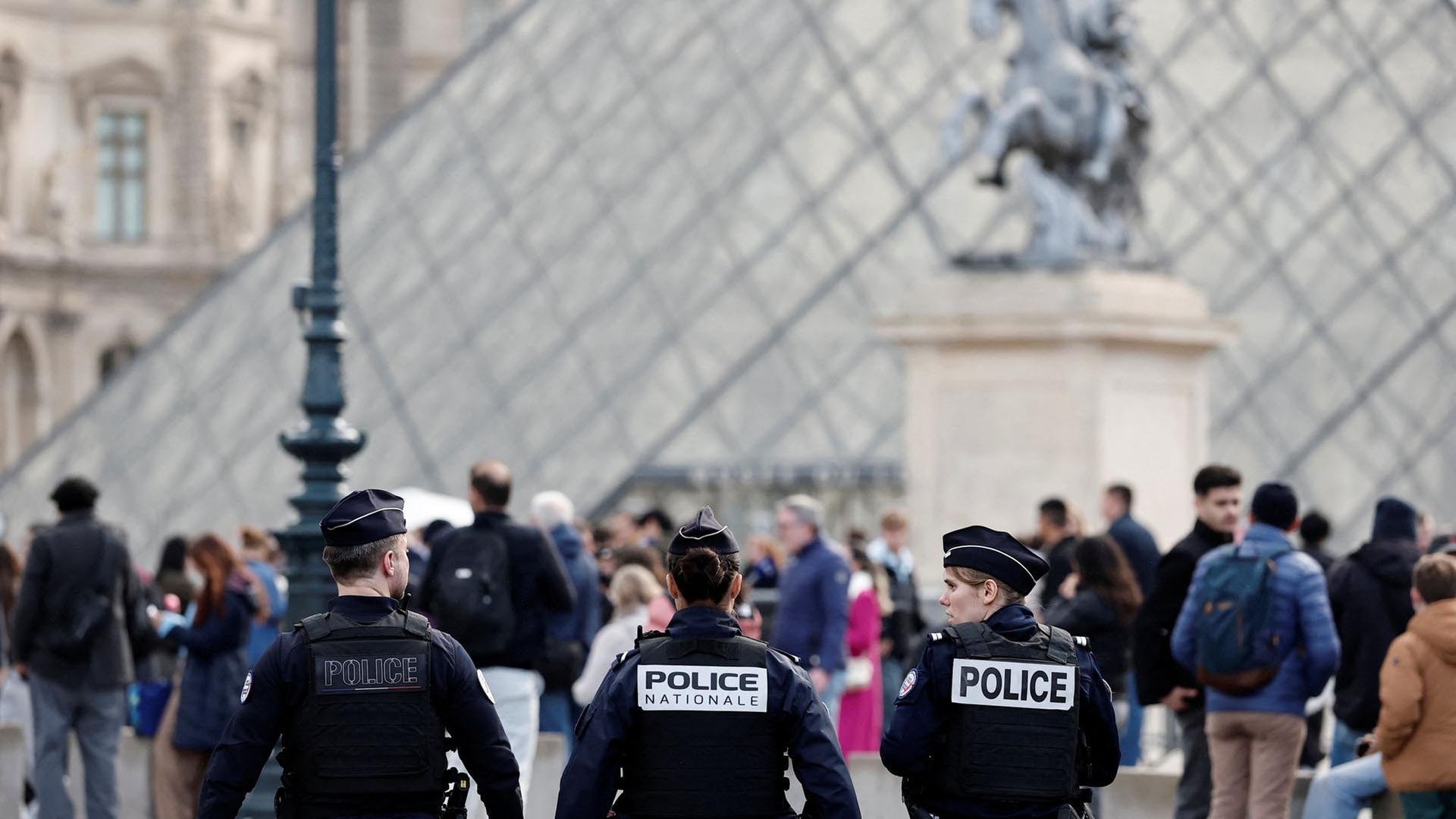 Französische Polizisten gehen in der Nähe der Glaspyramide des Louvre-Museums in Paris vorbei. | REUTERS