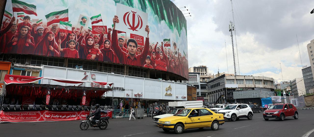 Eine große politische Plakatwand mit den iranischen Nationalflaggen am Valiasr-Platz in Teheran.
