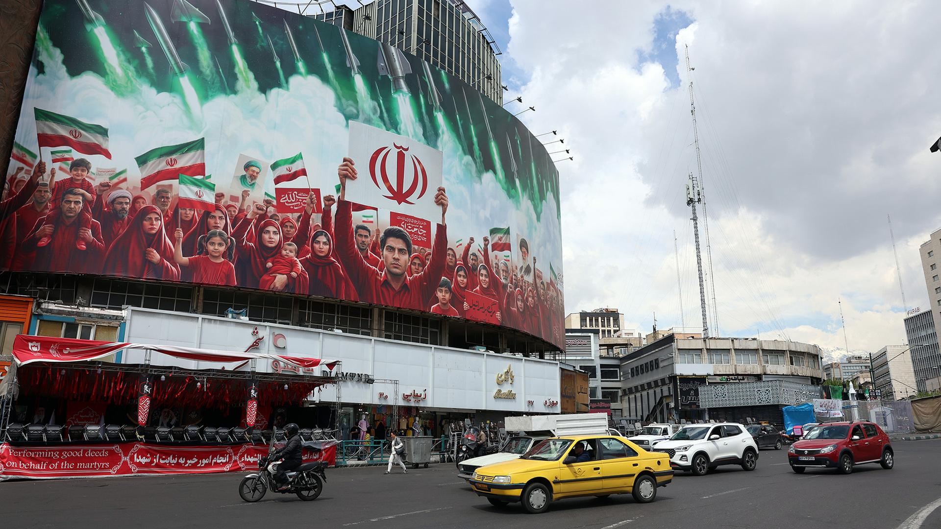 Eine große politische Plakatwand mit den iranischen Nationalflaggen am Valiasr-Platz in Teheran. | EPA