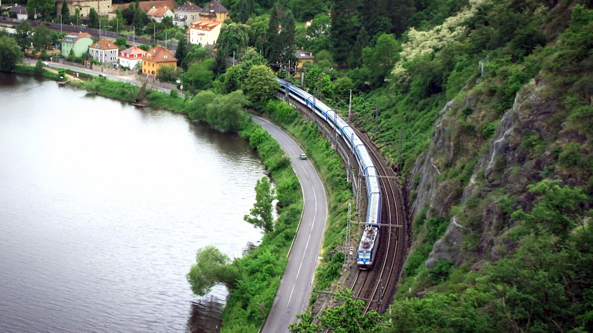 Eine Eisenbahn f�hrt durch ein Tal an einem Gew�sser entlang. | MDR