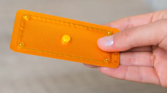 Eine Frau hält in einer Apotheke die "Pille danach" in der Hand.