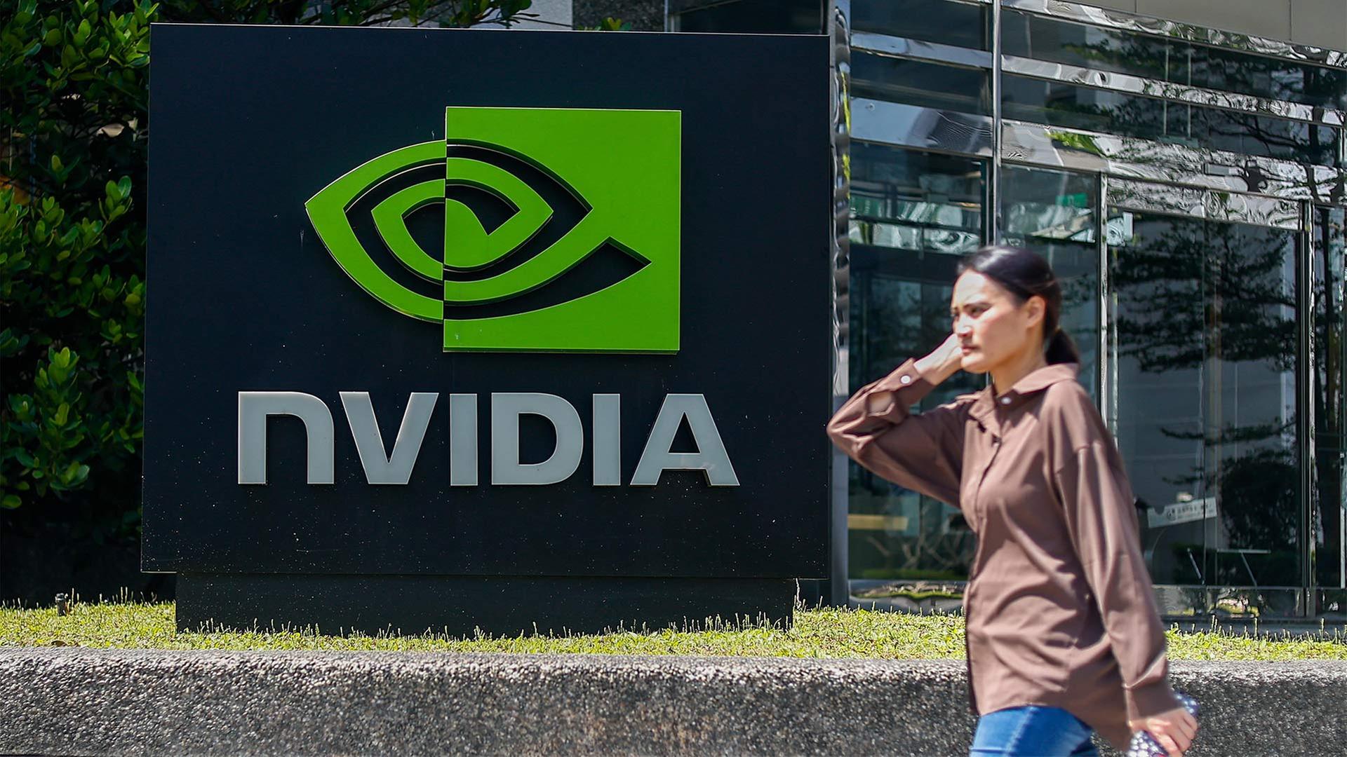 Passantin neben dem Nvidia-Logo auf einem Schild vor einem Unternehmensgebäude in Taiwan. | picture alliance / Anadolu