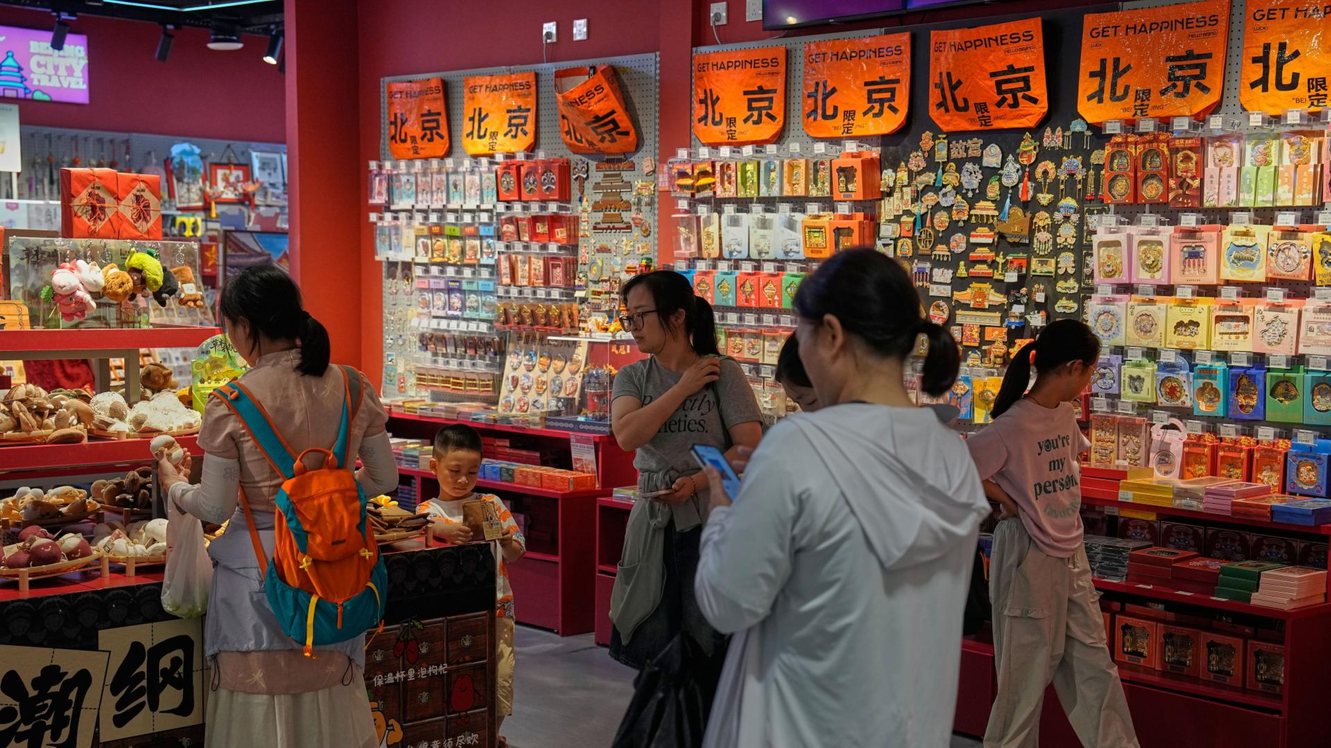 Menschen in einem Souvenir-GeschÃ¤ft in Beijing, China. | AP Photo/Andy Wong