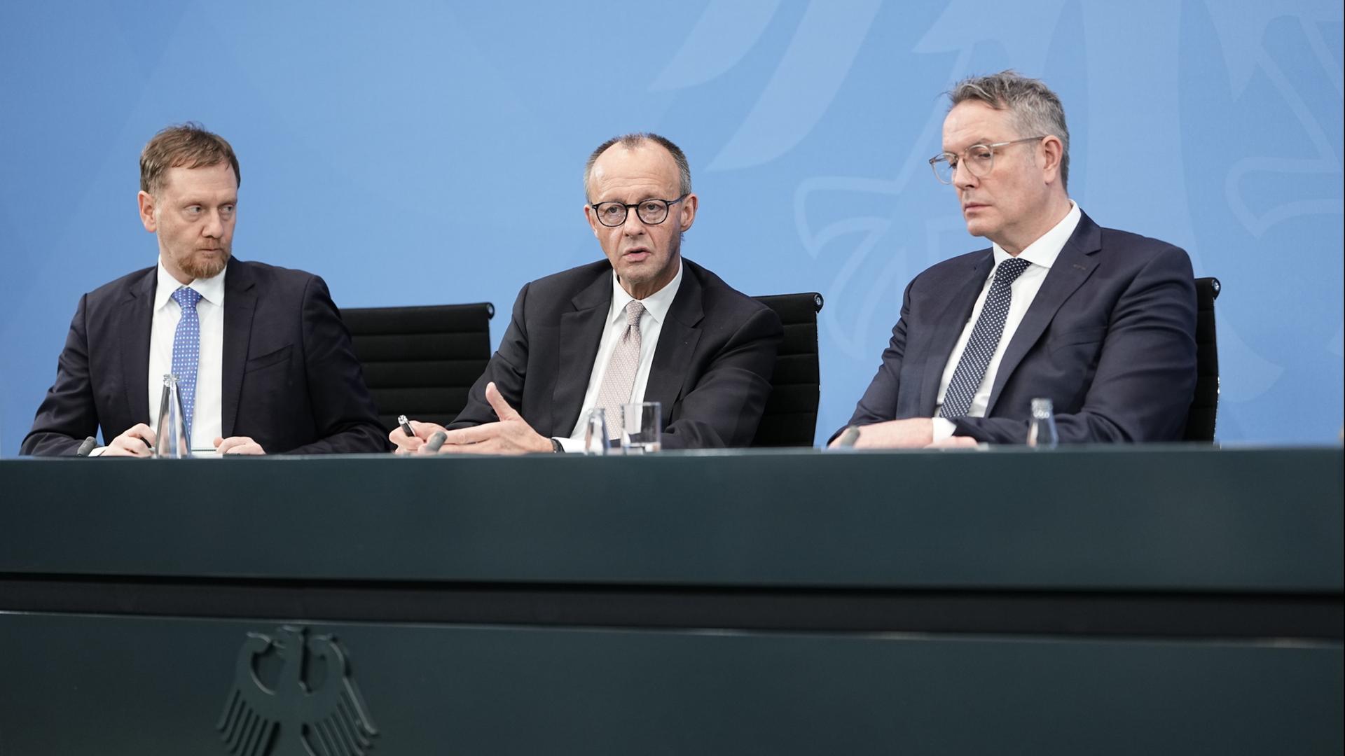 Michael Kretschmer, Friedrich Merz und Alexander Schweitzer. | dpa