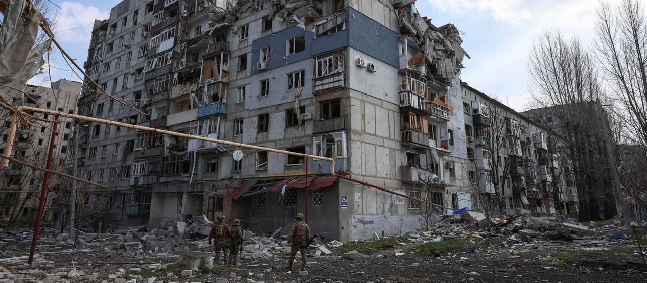 Soldaten stehen von einem zerstörten Haus in Pokrowsk