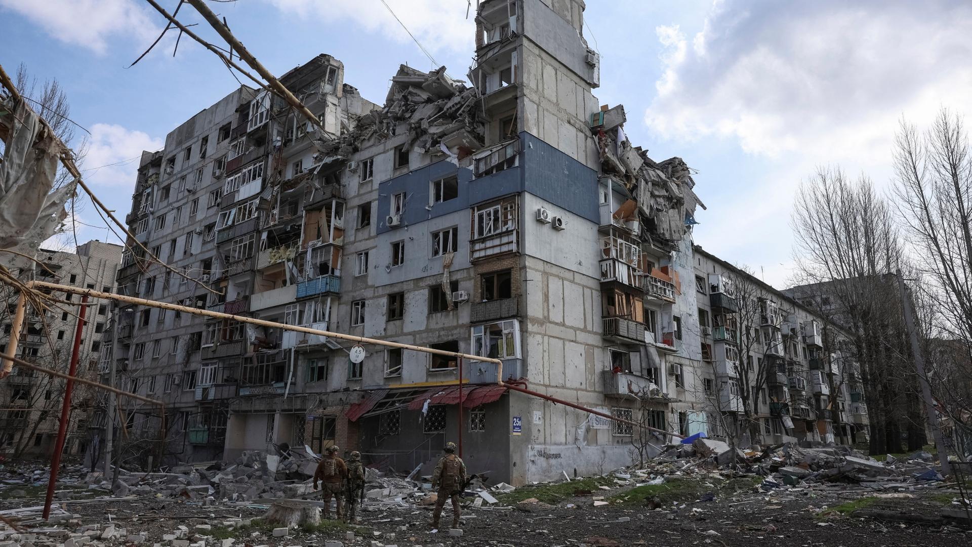 Soldaten stehen von einem zerstörten Haus in Pokrowsk | REUTERS