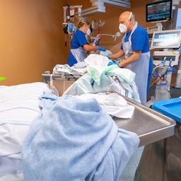 Pflegekräfte arbeiten mit einem Patienten in einem Intensivbett-Zimmer der Asklepios Klinik Gauting.