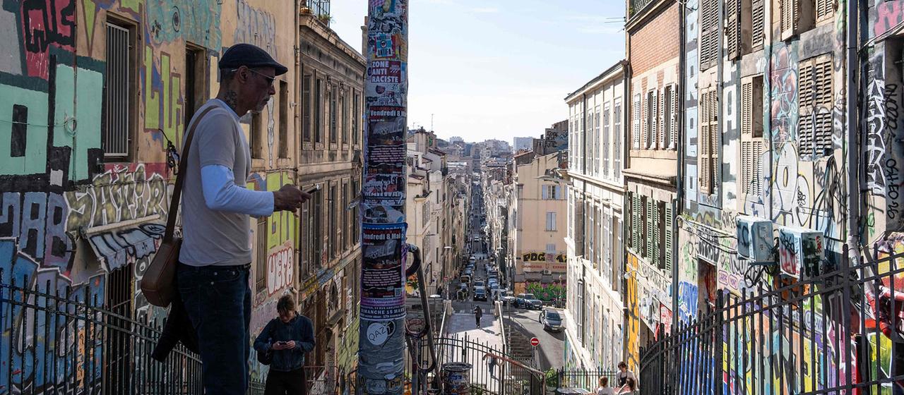 Zwei Personen in einer mit Graffiti bedeckten Gasse in Marseille.