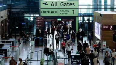 Passagiere sind in einem Terminal am Berliner Flughafen BER unterwegs.