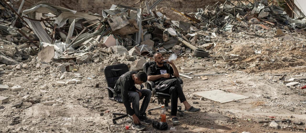 Palästinenser sitzen in Al-Eizariya inmitten von Schutt 