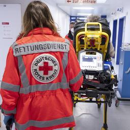 Eine Notfallsanitäterin schiebt eine Seniorin nach einem Schlaganfall auf einer Trage in die Notaufnahme eines Krankenhauses.