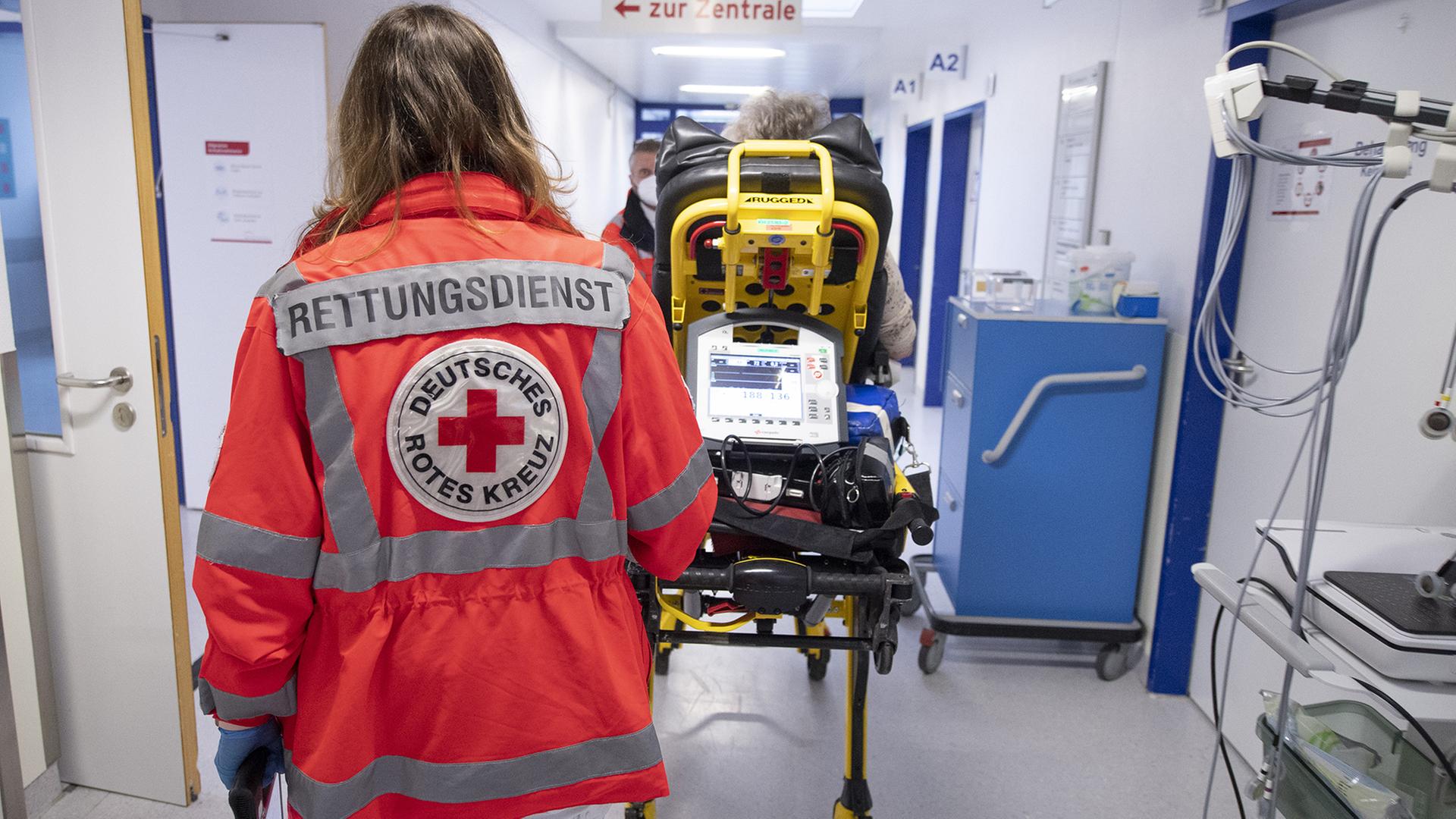 Eine Notfallsanitäterin schiebt eine Seniorin nach einem Schlaganfall auf einer Trage in die Notaufnahme eines Krankenhauses. | dpa