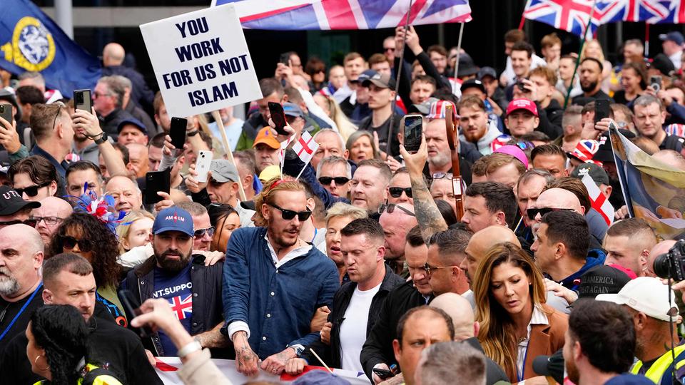 Tommy Robinson (Bildmitte, schwarze Jacke) steht inmitten von Demonstranten.