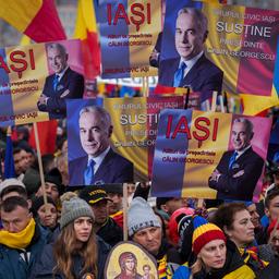 Menschen halten Bilder von C.Georgescu in Bukarest, Rumänien hoch.