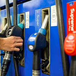 Ein Autofahrer hängt an einer Tankstelle eine Zapfpistole zurück