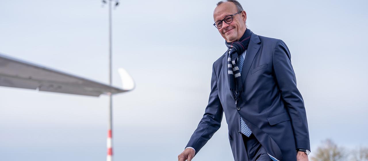 Friedrich Merz geht am Flughafen Richtung Flugzeug.