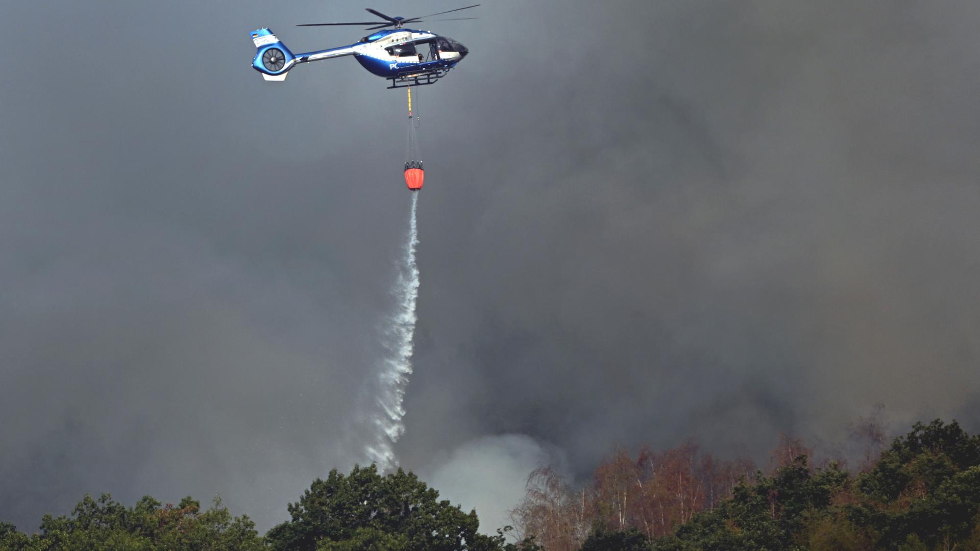  Ein Polizeihubschrauber unterst�tzt die L�scharbeiten beim Waldbrand im H�rtgenwald | dpa