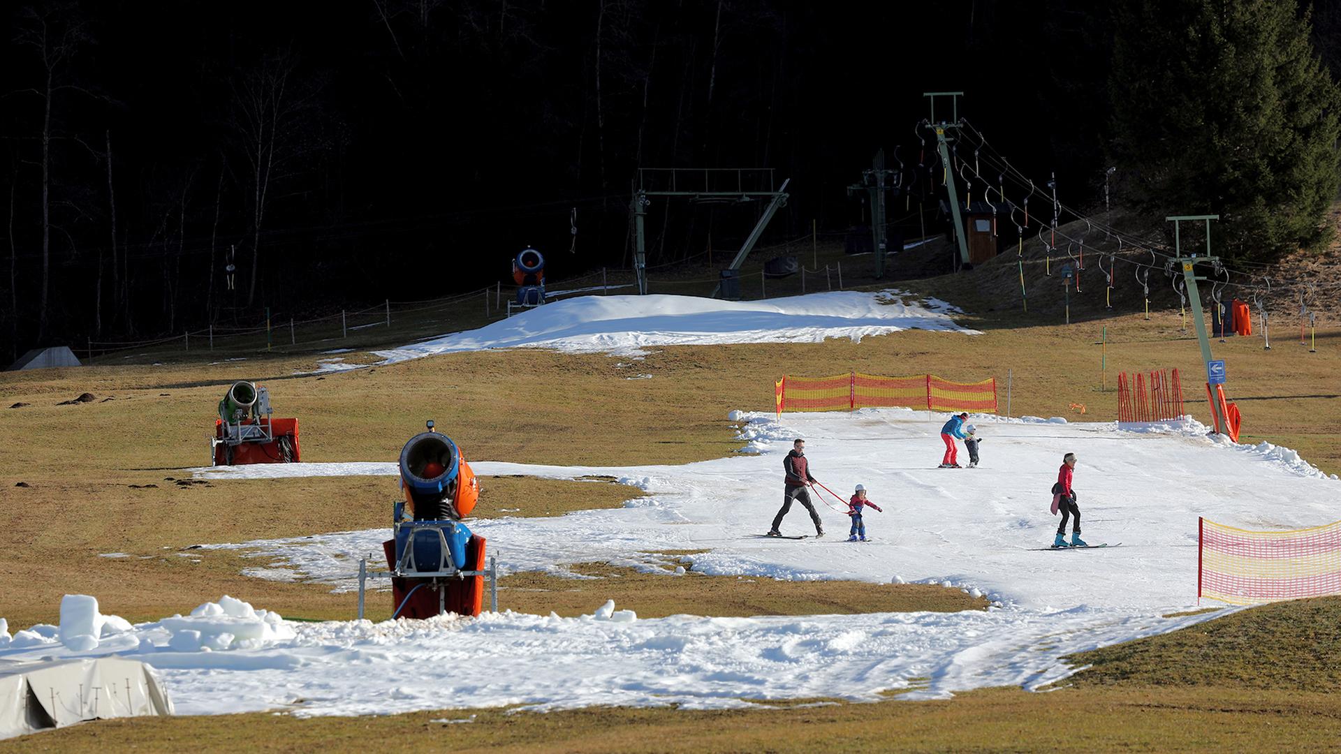 Skifahrer üben an einer Skipiste auf dem von Schneekanonen produzierten Kunstschnee. | dpa