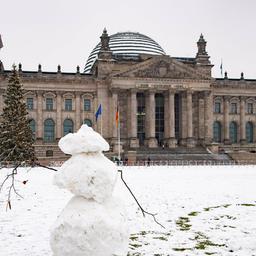 Der Deutsche Bundestag, Reichstag, davor steht ein geschmueckter Weihnachtsbaum, im Vordergrund ein Schneeman