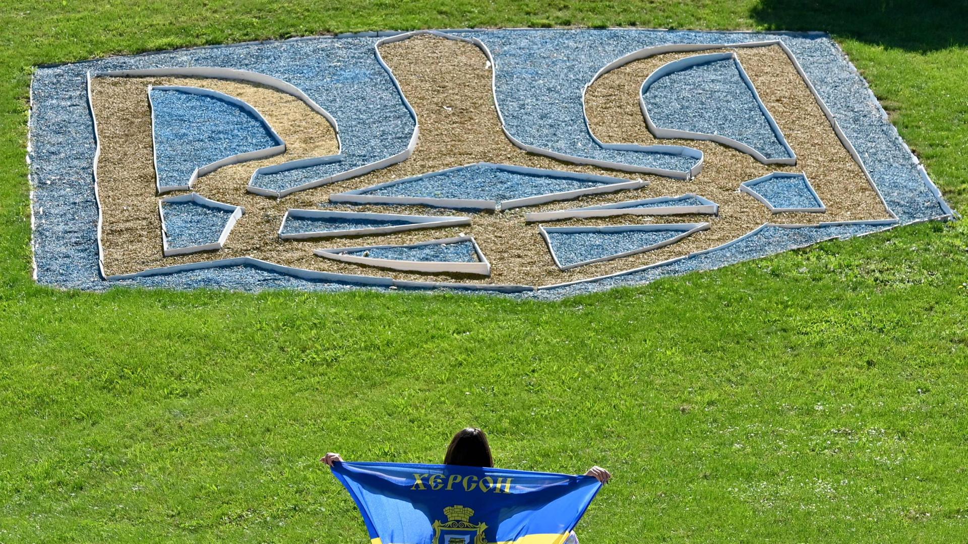 Das ukrainische Dreizack-Symbol ist auf einem Rasen in Kiew zu sehen. | AFP