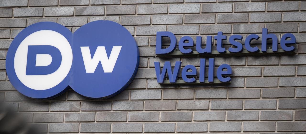 Das Logo des Auslandsrundfunks Deutsche Welle ist am Eingang zum Hauptstadt-Sitz des Senders angebracht.