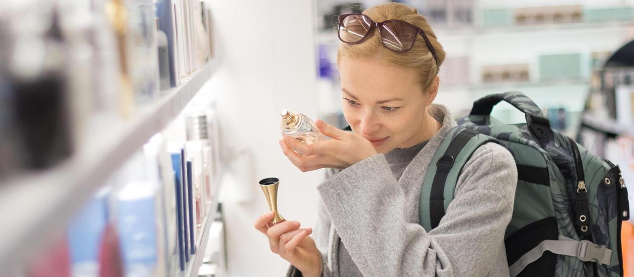 Eine Frau testet Parfüm in einem Laden.