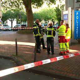 Fünf Einsatzkräfte stehen vor dem Polizeigebäude