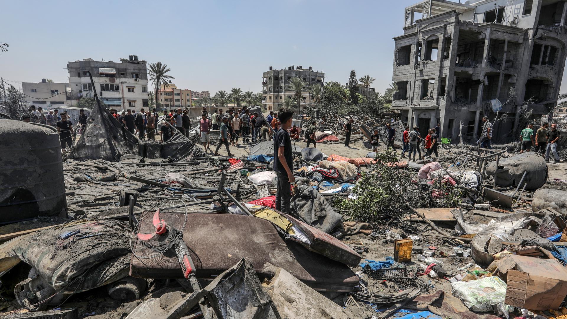 Menschen inspizieren die Zerstörung nach einem Luftangriff in Chan Junis