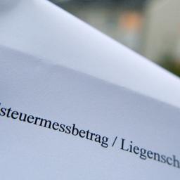 Ein Reihenhausbesitzer hält einen Grundbesitzabgabenbescheid der Stadt Frankfurt in der Hand.