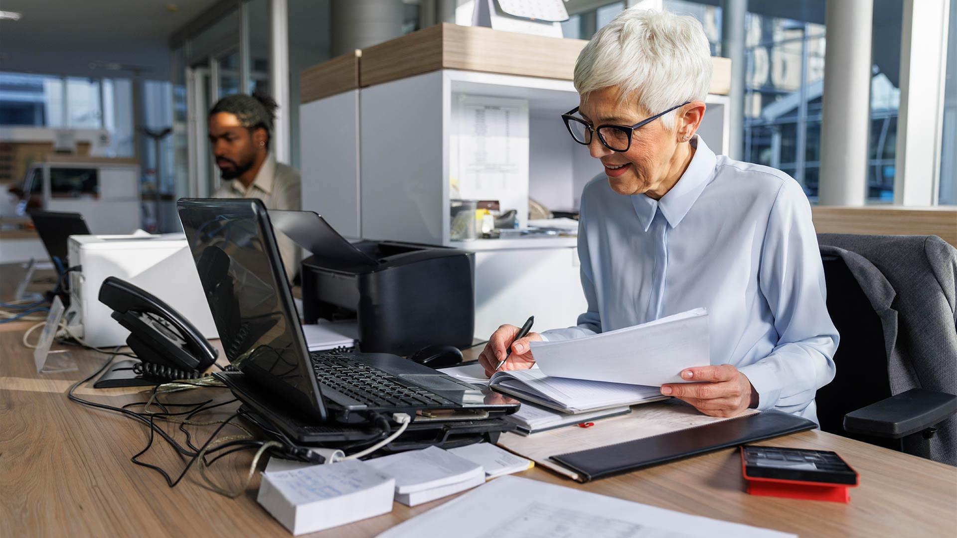 Frau der Babyboomer Generation in einem BÃ¼ro bei der Arbeit hinter einem Laptop. | picture alliance / Westend61