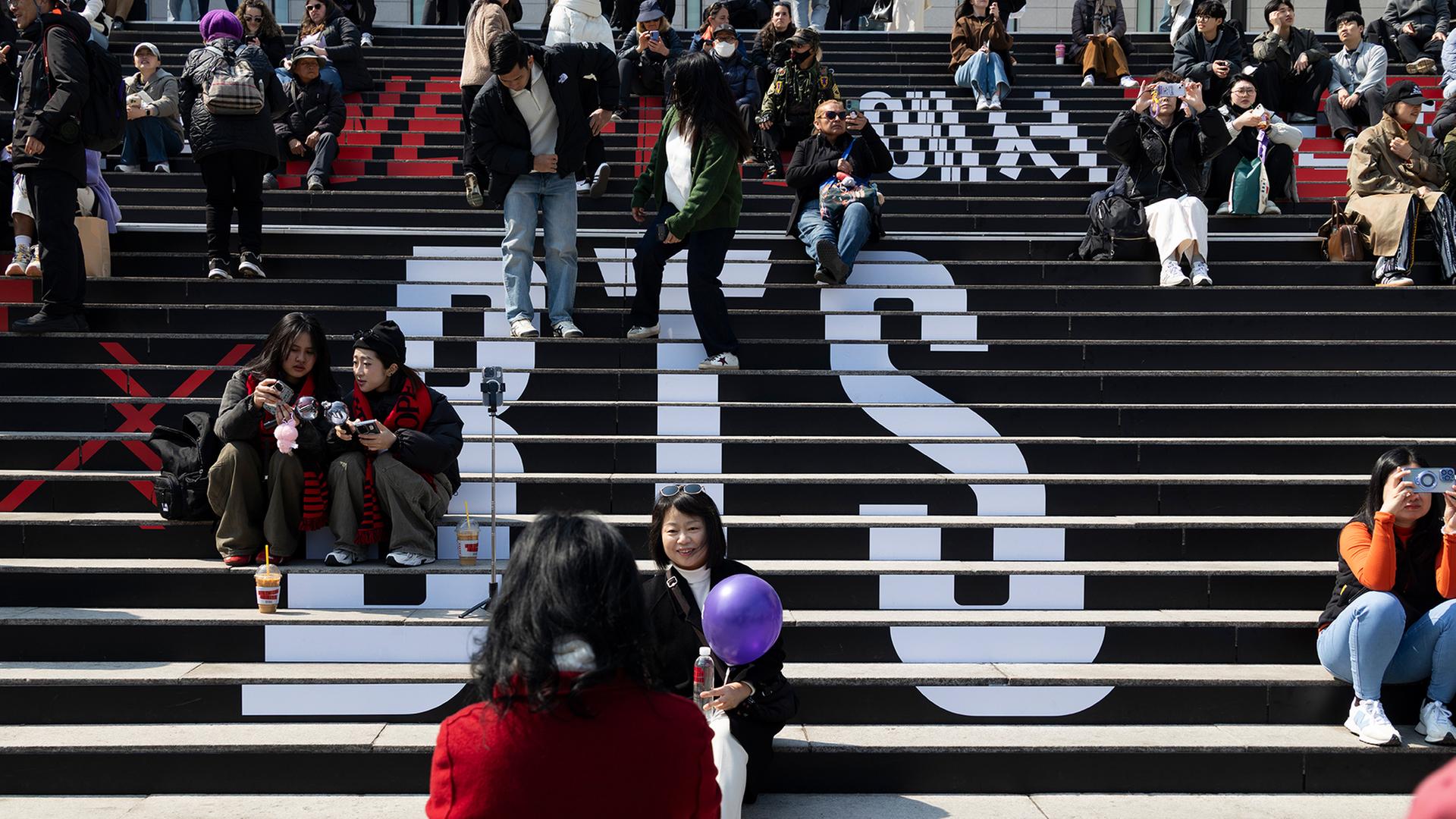 Fans machen Fotos auf einer Treppe mit der Aufschrift 