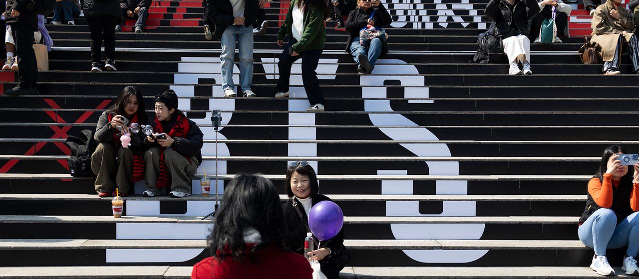 Fans machen Fotos auf einer Treppe mit der Aufschrift "BTS".