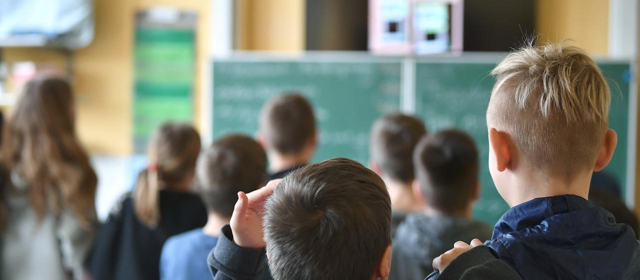 Schüler und Schülerinnen schauen auf die Tafel.