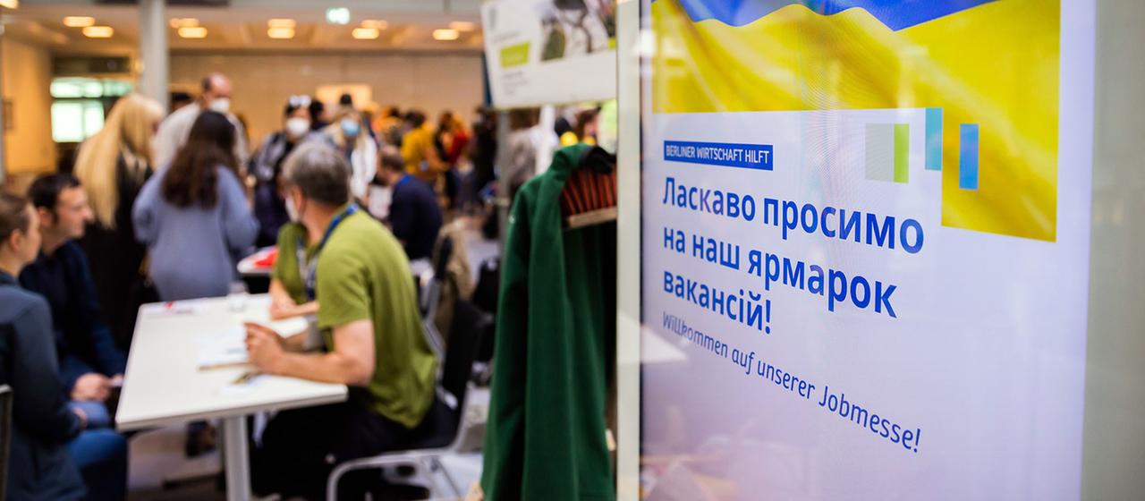 Menschen unterhalten sich bei einer Jobmesse für ukrainische Geflüchtete.