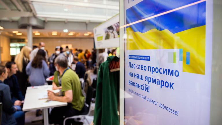 Menschen unterhalten sich bei einer Jobmesse für ukrainische Geflüchtete.